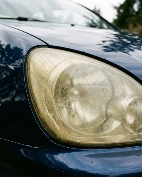 A yellowed, oxidised and hazy plastic headlight lens.