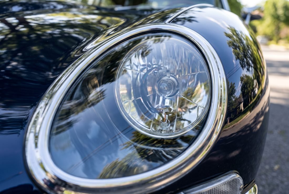 The same headlight from the same angle, the lens clear with the reflector sharply visible.