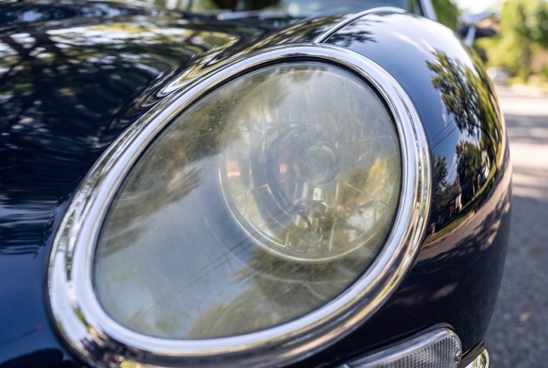 A heavily yellowed and clouded headlight lens with the internals barely visible.
