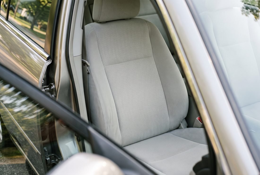 The same cloth seat from the same angle, the fabric even and bright with the staining lifted.